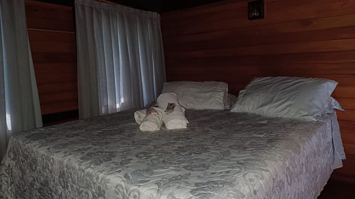 Quarto da cabana com cama Queen preparada para os hóspedes